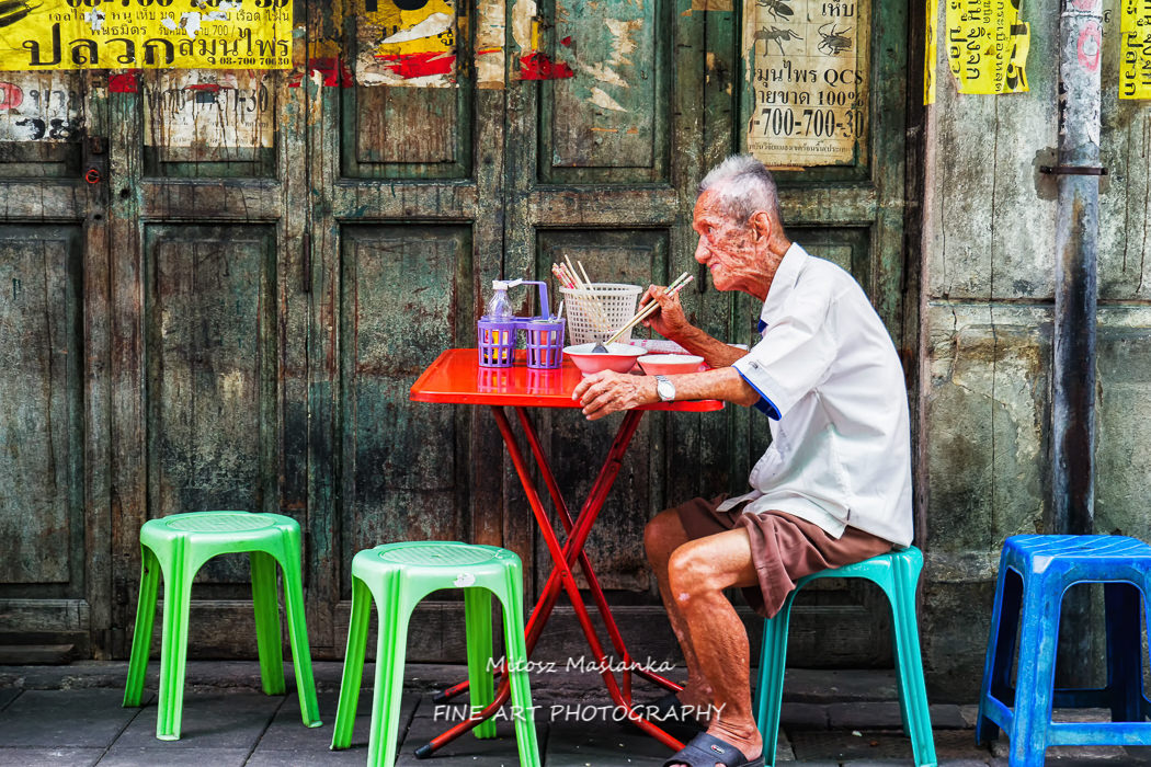 Unidentified man eats on a street in chinatown district, Bangkok, Thailand. Chinatown is renowned for its street food and outdoor dining.