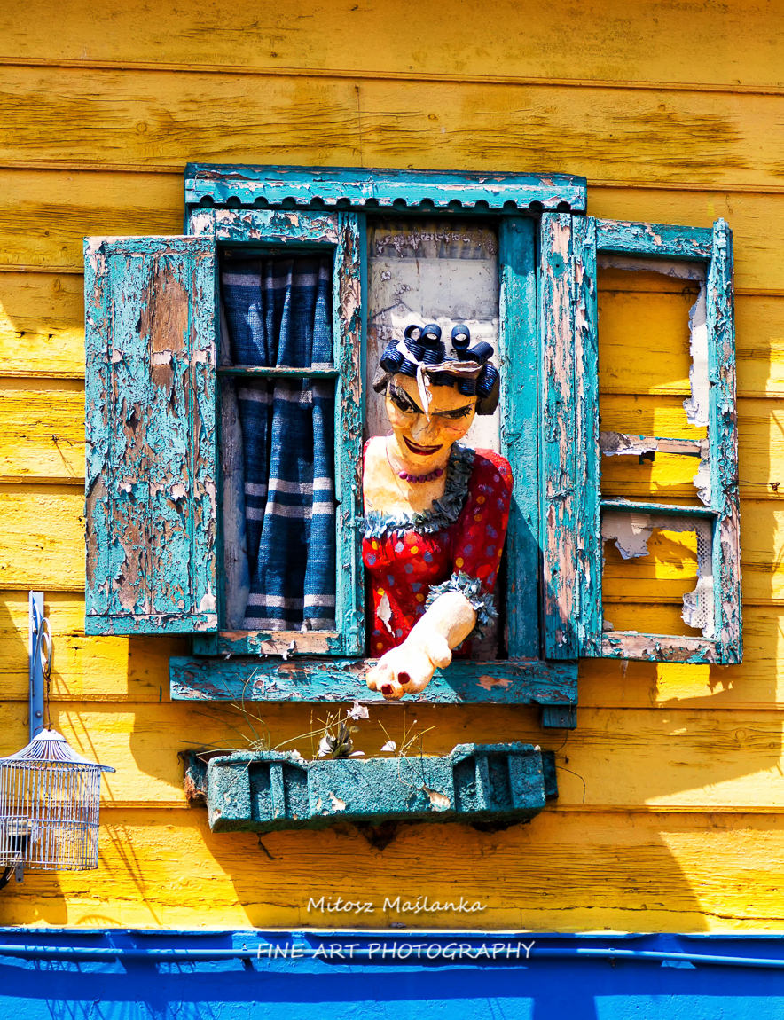 Statue of a woman peeking out of a window in La Boca, Buenos Aires