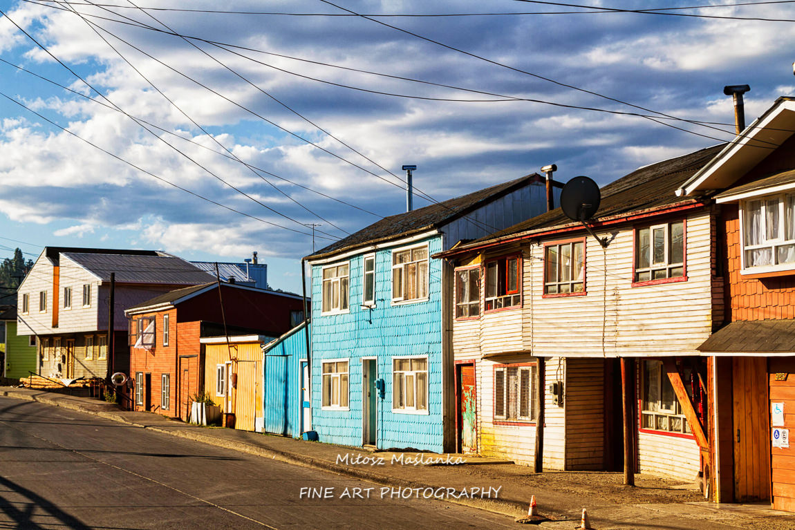 Row of vivid colourful timber, wooden houses, Castro, Chiloe Island, Chile. Lighted by warm summer light.