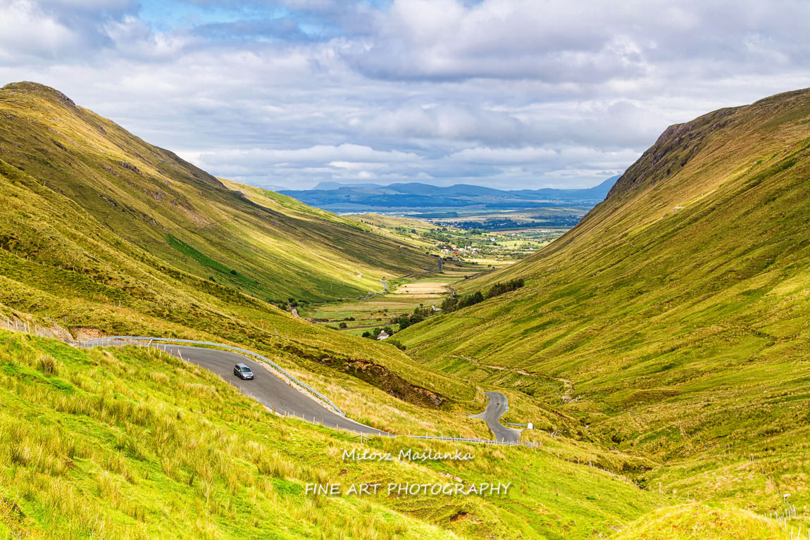 Summer landscape of mountains, hills and meadows in popular and picturesque Glengesh Pass which is part of the Wild Atlantic Way between Ardara and Glencolumbkille. The route is a very popular road.