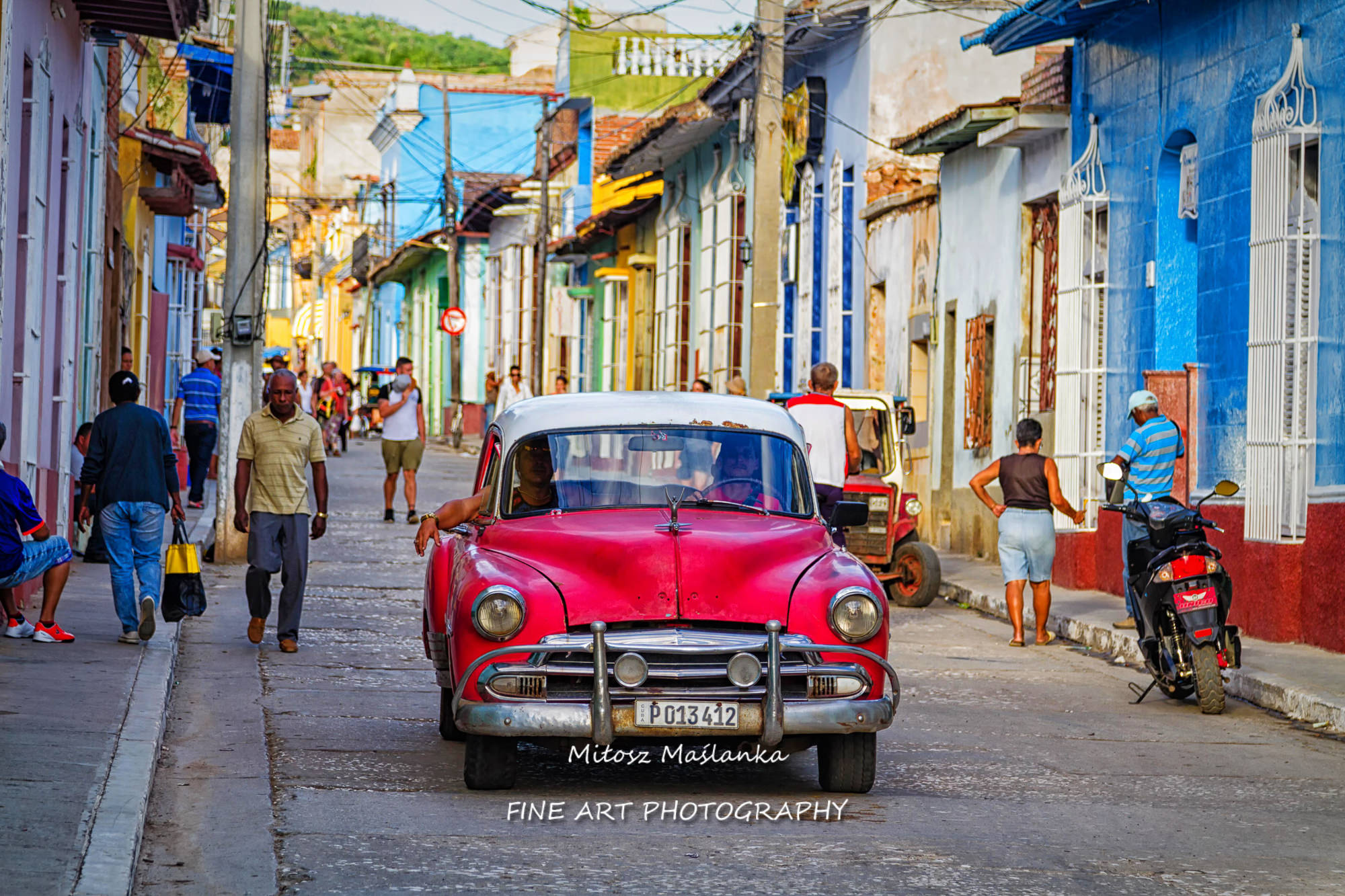 Typical street scene with people, old cars and colorful buildings. Trinidad is a popular tourist destination and famous for its architecture and vintage style