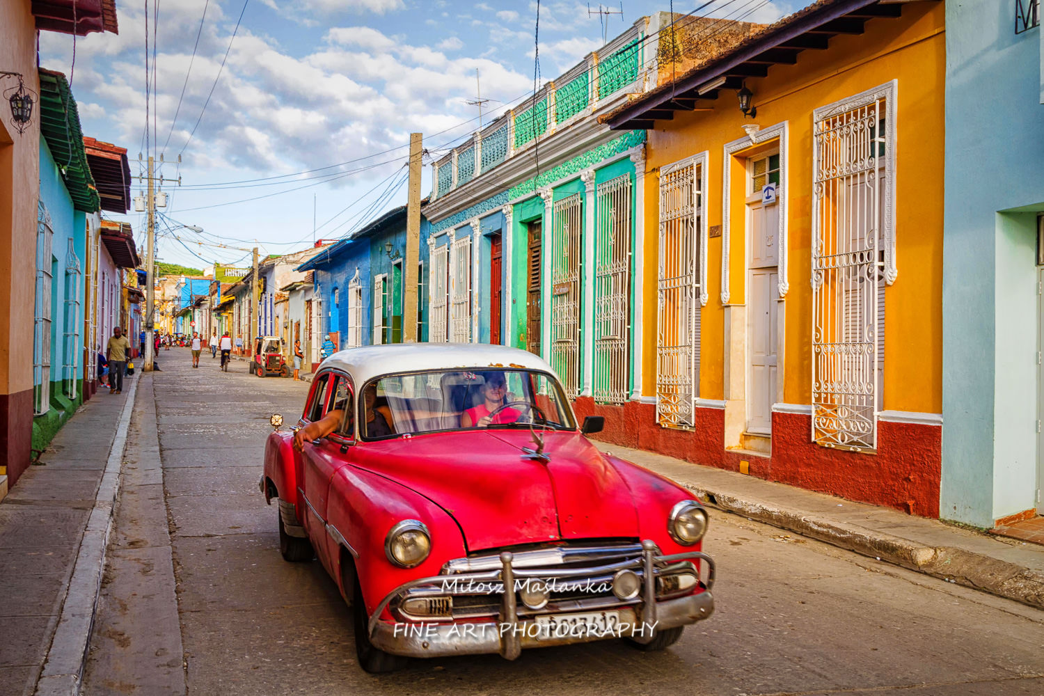 Typical street scene with people, old cars and colorful buildings. Trinidad is a popular tourist destination and famous for its architecture and vintage style