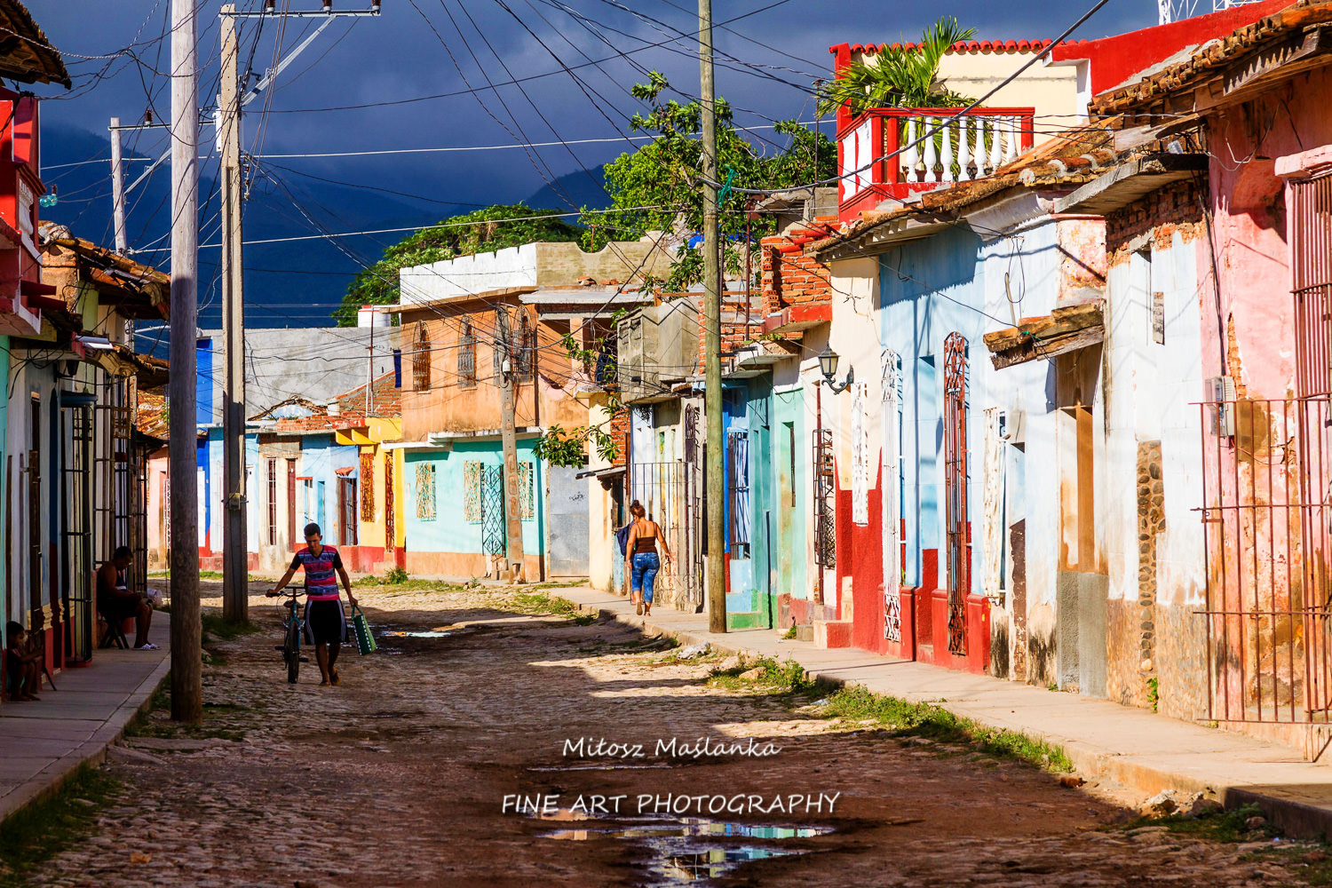 View of Trinidad street with colorful (red, yellow, green, blue) houses, cobbled road and bars in windows. Trinidad is a UNESCO listed city and popular destination.