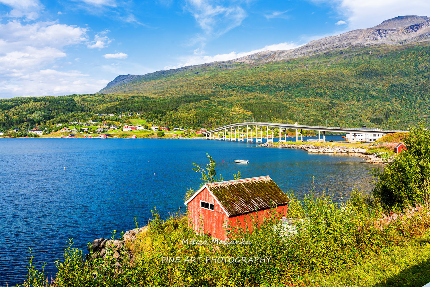 Red wooden hut by the fjord